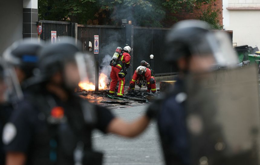 Firefighters extinguish a fire at the entrance of the Leonard de Vinci secondary school following a blockading action by protesting students, in Paris on October 2, 2026.