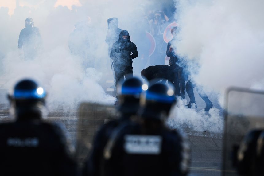 Police officers stand in front of protesters amid tear gas as demonstrators carry out blockading action near the Kerichen high school in Brest, western France, on October 2.