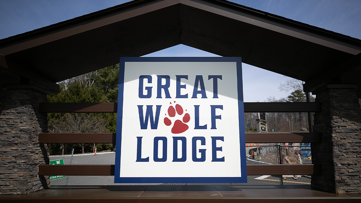 Great Wolf Lodge sign beneath a wooden canopy beside a landscaped entrance