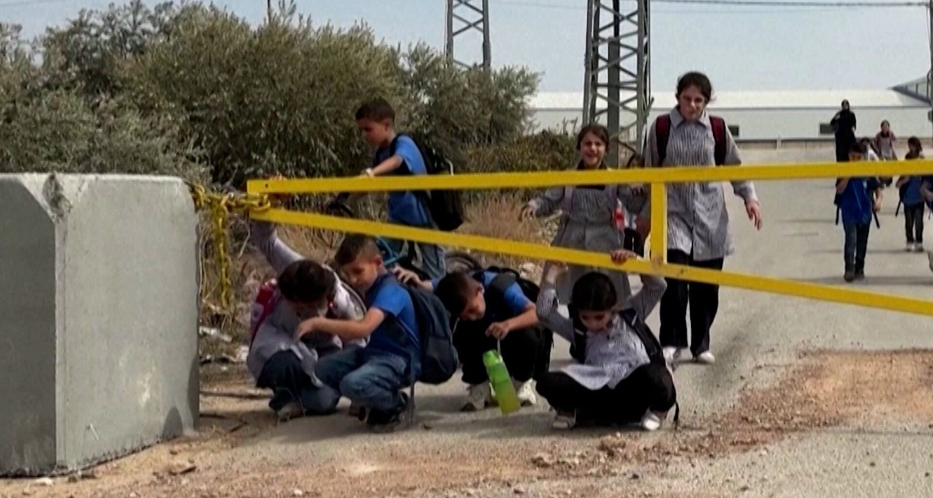 Palestinian children crawl under Israeli military gates to get to school | Israel-Palestine conflict News