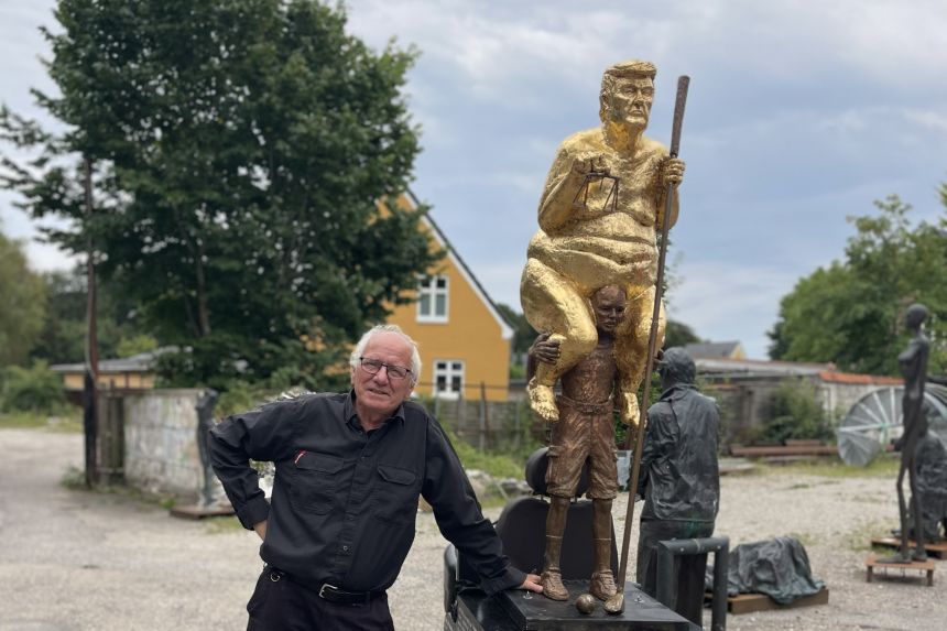 Danish artist Jens Galschiøt with his 23-carat-gold-leaf-covered sculpture of Trump sitting on the back of a frail man.