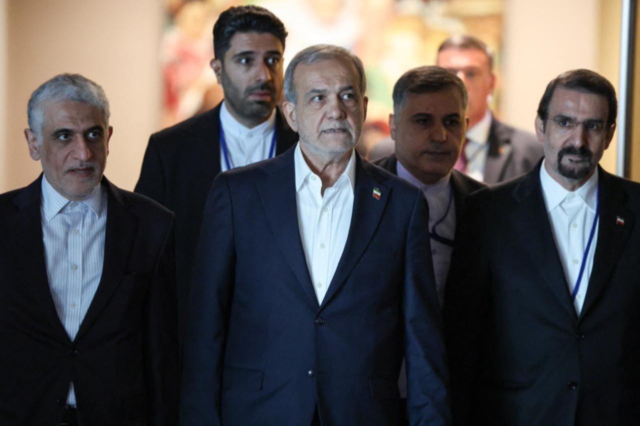 Irans President Masoud Pezeshkian (C) walks on his way to a bilateral meeting with France