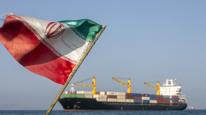 An Iranian flag flutters in the wind as ships remain anchored on May 16, 2026 in the Strait of Hormuz near Larak Island, Iran.