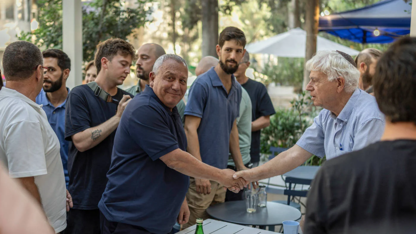 Gadi Eisenkot (centre) holds a meet-and-greet at a coffee shop in Jerusalem on 12 August 2026 (AFP)
