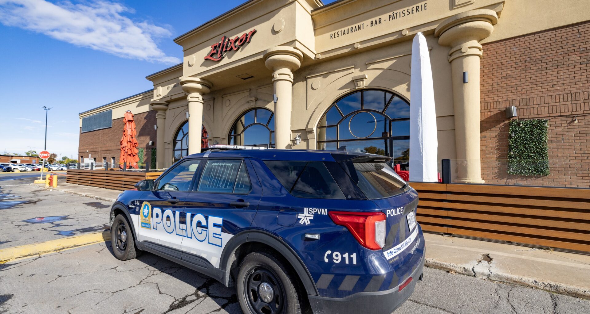 The front of Elixor restaurant with a police vehicle parked in front.