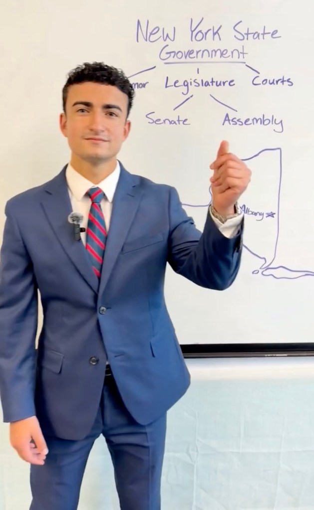David Hassid standing in front of a whiteboard detailing the New York State Government.