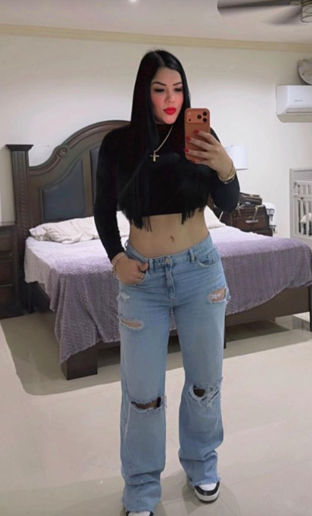 Mexican TikTok influencer Cindy Tamez taking a mirror selfie in a bedroom.