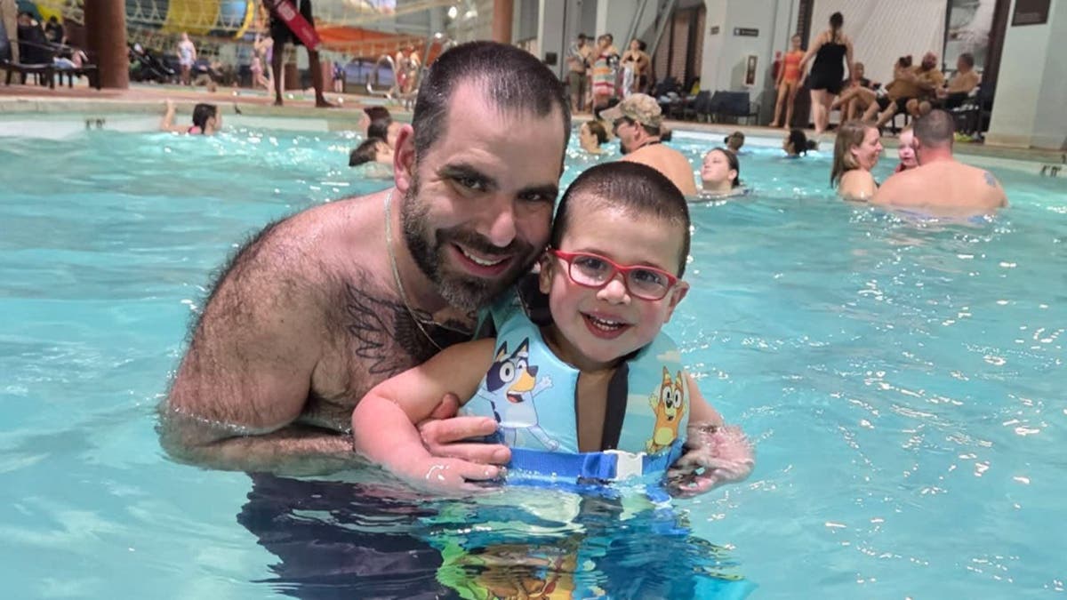 image shows father and son in pool
