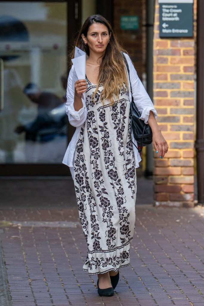 Mahrah Al Nahyan walking outside while holding papers.