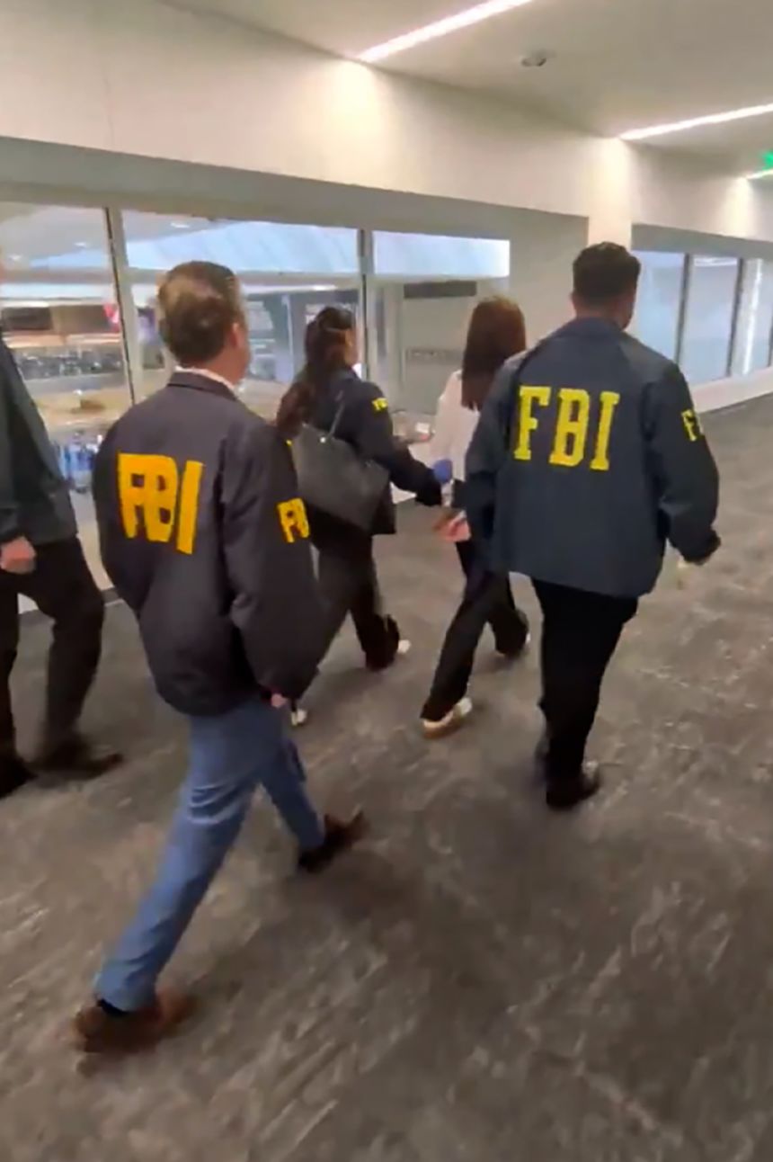 Zhang was placed in handcuffs at Los Angeles International Airport and escorted by FBI agents on Sunday.