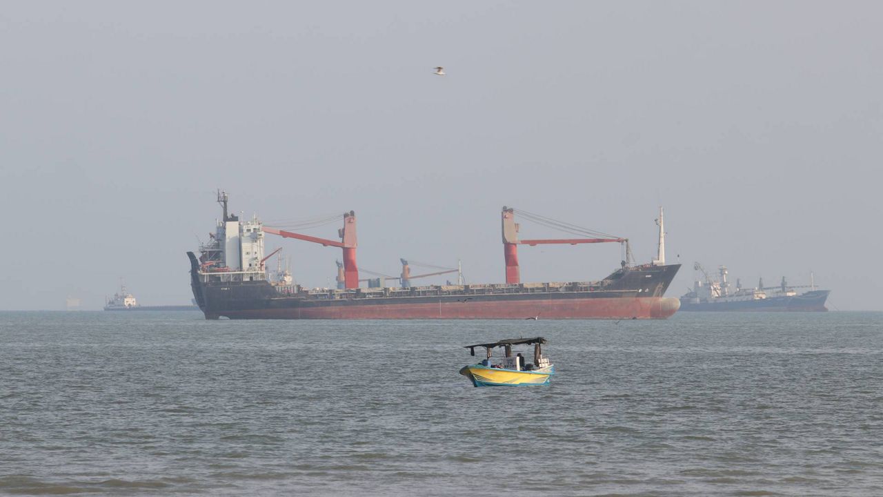 A boat floats as commercial vessels appear anchored in the Strait of Hormuz off Bandar Abbas, Iran, Tuesday, Oct. 13, 2026. (Razieh Poudat/ISNA via AP)