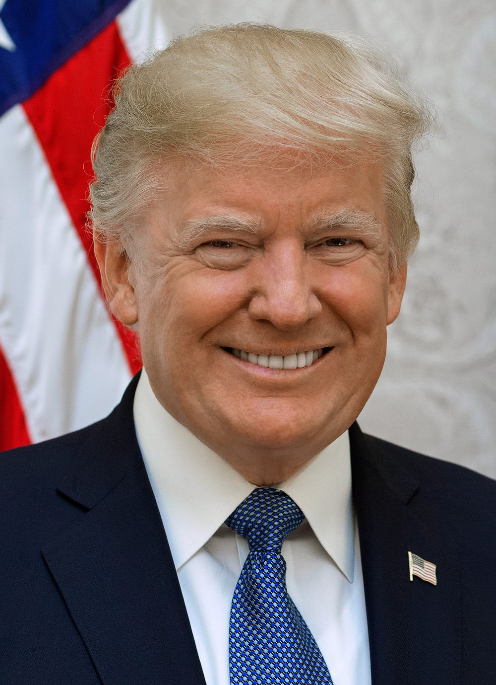 Close-up portrait of a man smiling, US flag in the background